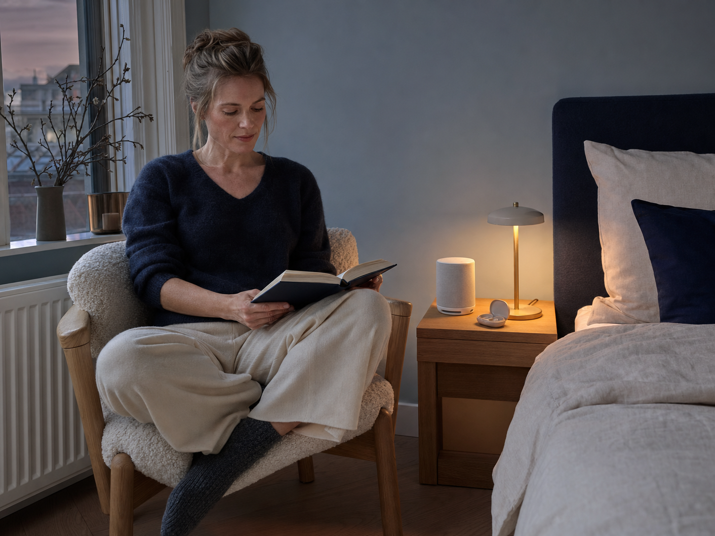 European woman reading beside a white-noise machine and earplugs